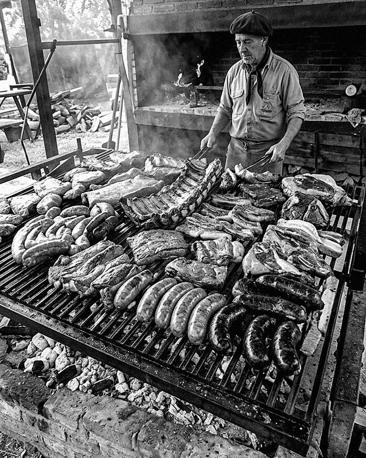 Asador frente a una parrilla llena